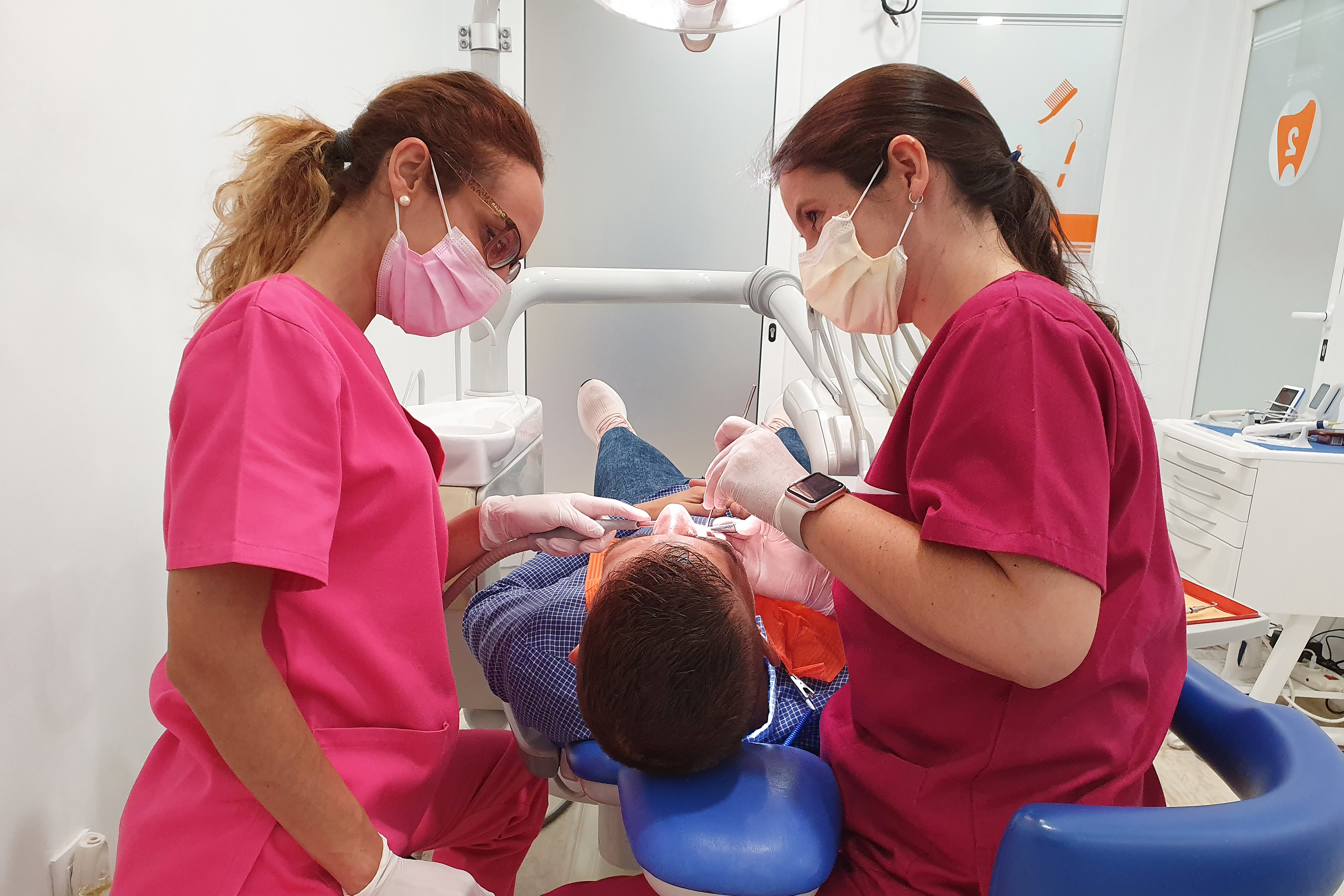 Dra Arboleas Moreno e higienista Carmen Jiménez tratando a un paciente en gabinete